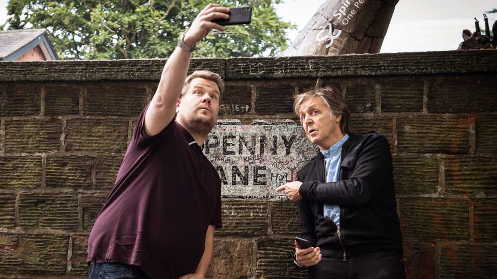Paul McCartney and James Corden take a selfie in front of Penny Lane.