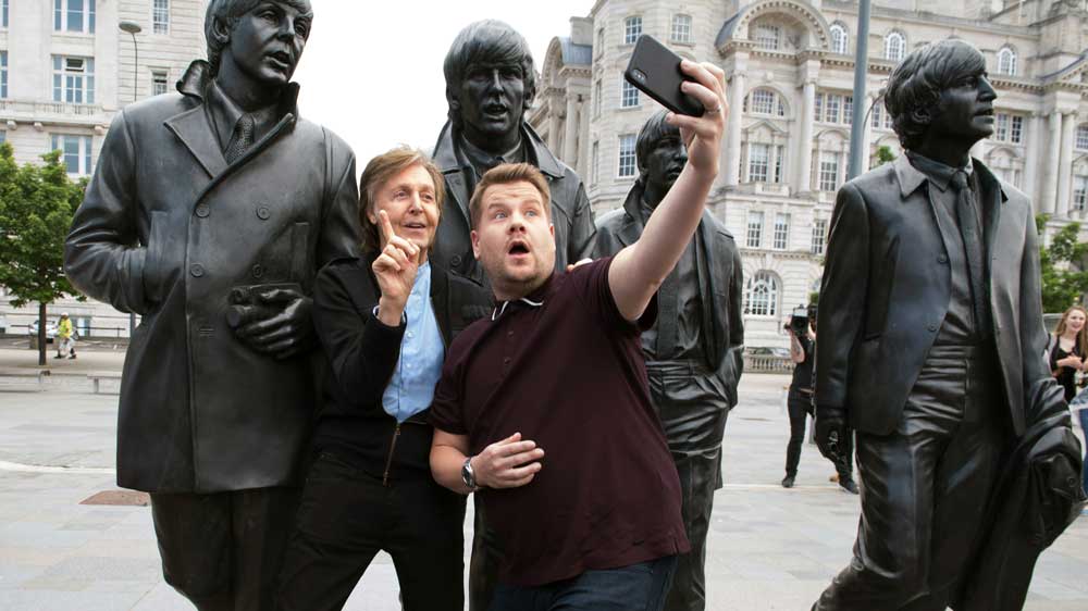 Paul McCartney and James Corden take a selfie in front of the Beatles statue in Liverpool.