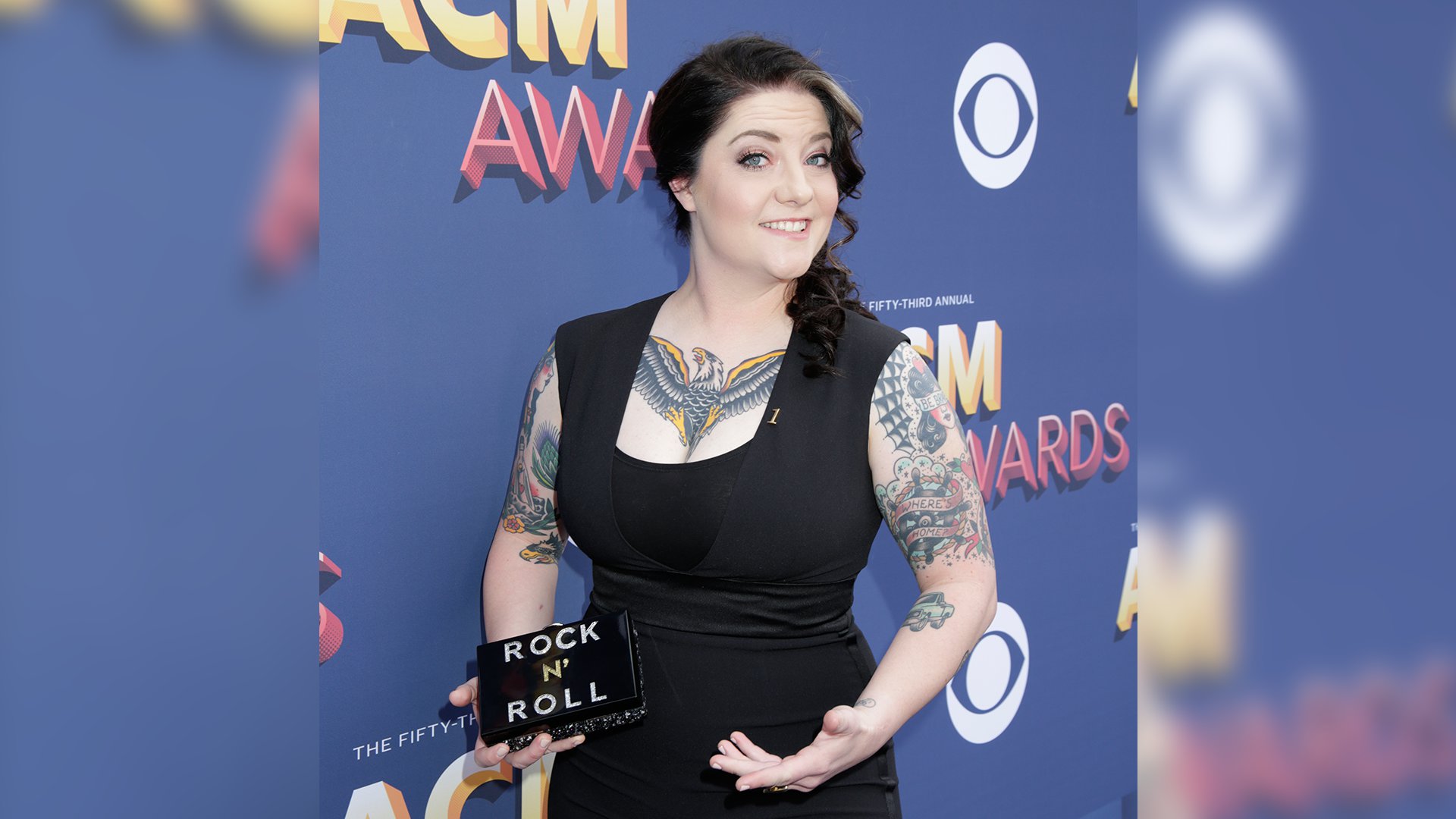 Singer Ashley McBryde pairs a simple black dress with her colorful tattoos.