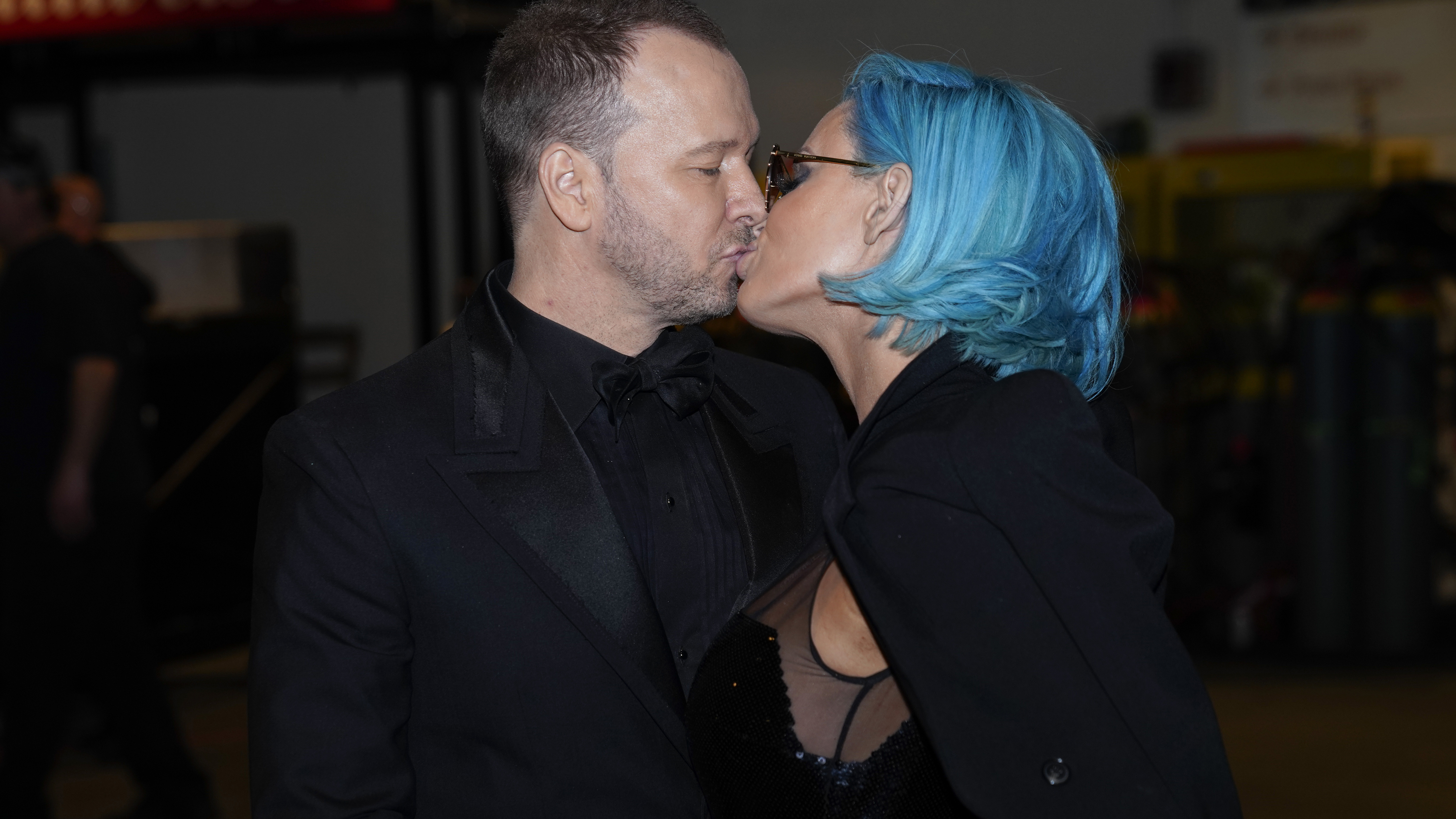 Blue Bloods star Donnie Wahlberg kisses his wife, Jenny McCarthy, backstage at the 60th Annual GRAMMY Awards.