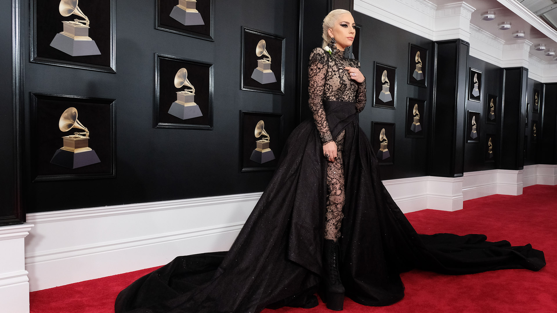 Lady Gaga pours herself onto the 60th Annual GRAMMY Awards red carpet in a black lace jumpsuit and long black train.