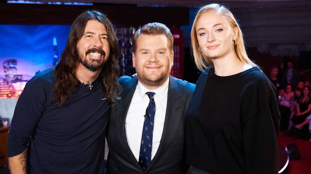 Dave Grohl, James Corden, and Sophie Turner pose for a group shot. 
