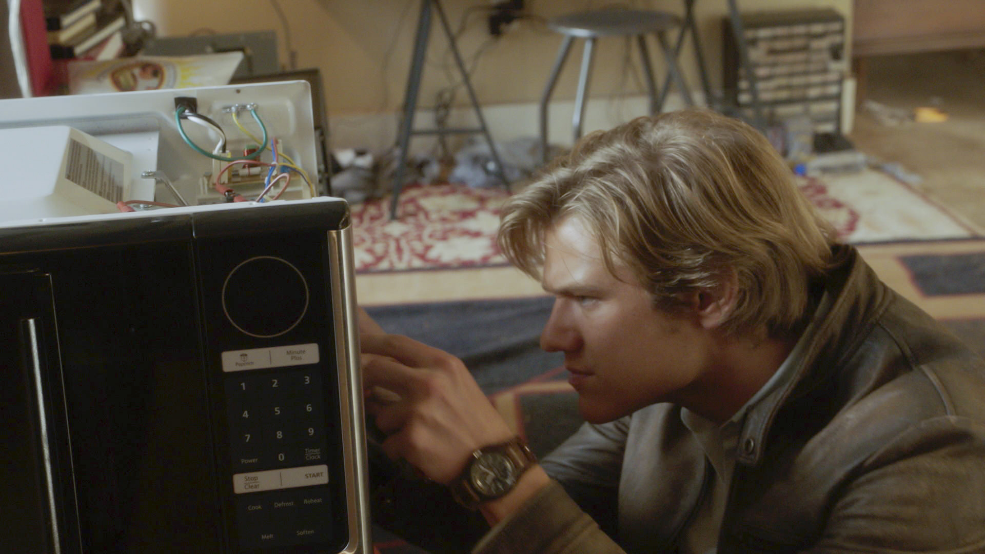 MacGyver dives into a microwave's electronics. 