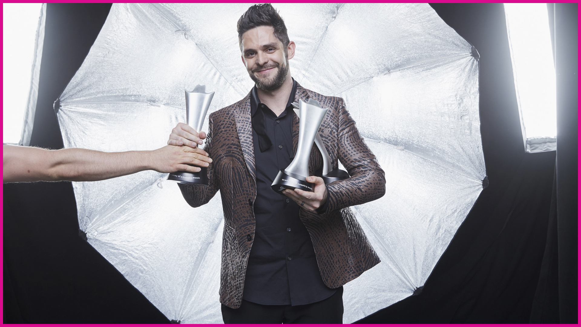 Thomas Rhett cradles two shiny ACM statues in his arms after a big night in Vegas!