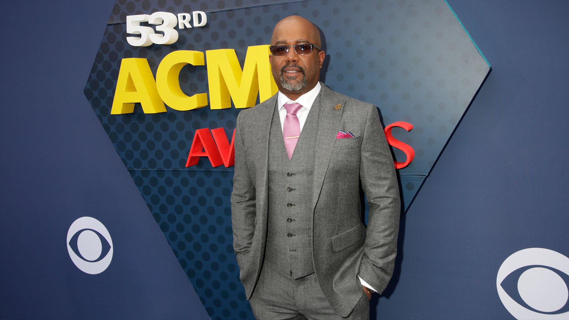 Darius Rucker accents his crisp gray suit with a pink tie and matching pocket square. 