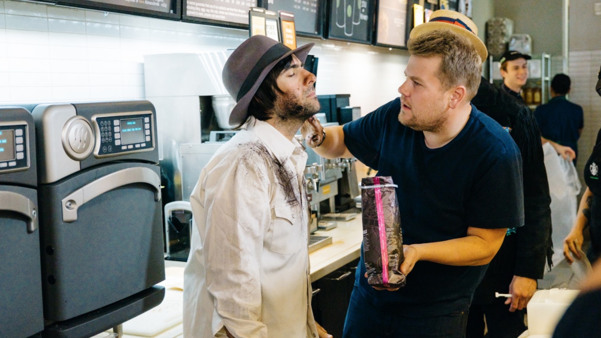James gently applies a healthy dose of ground coffee to Jason's face.