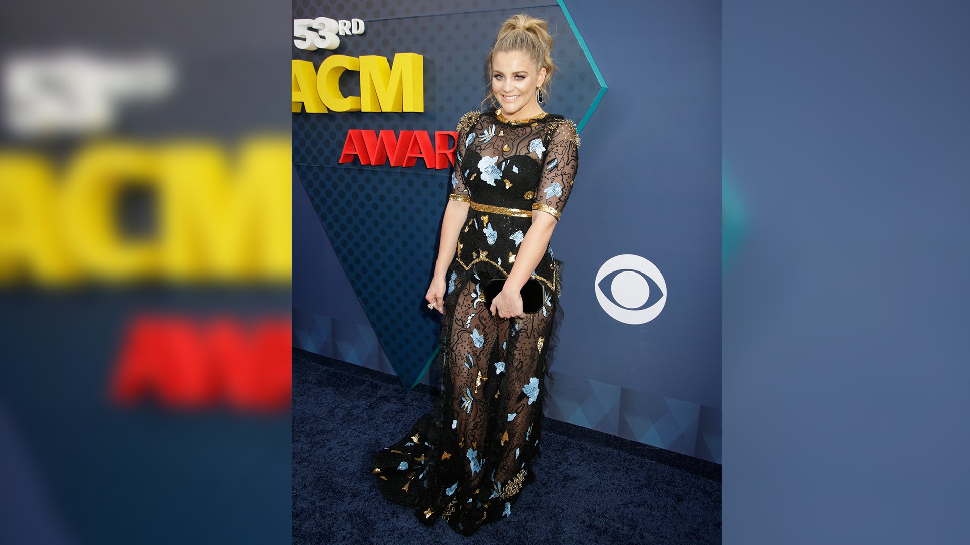 New Female Vocalist of the Year winner Lauren Alaina wears a high ponytail and heavenly black gown with floral appliqués.