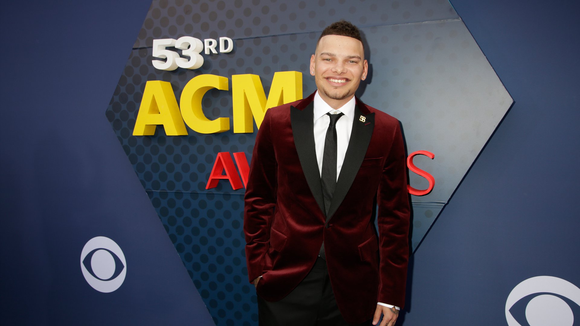 Kane Brown can't stop smiling while wearing a lush velvet blazer on the ACM red carpet.