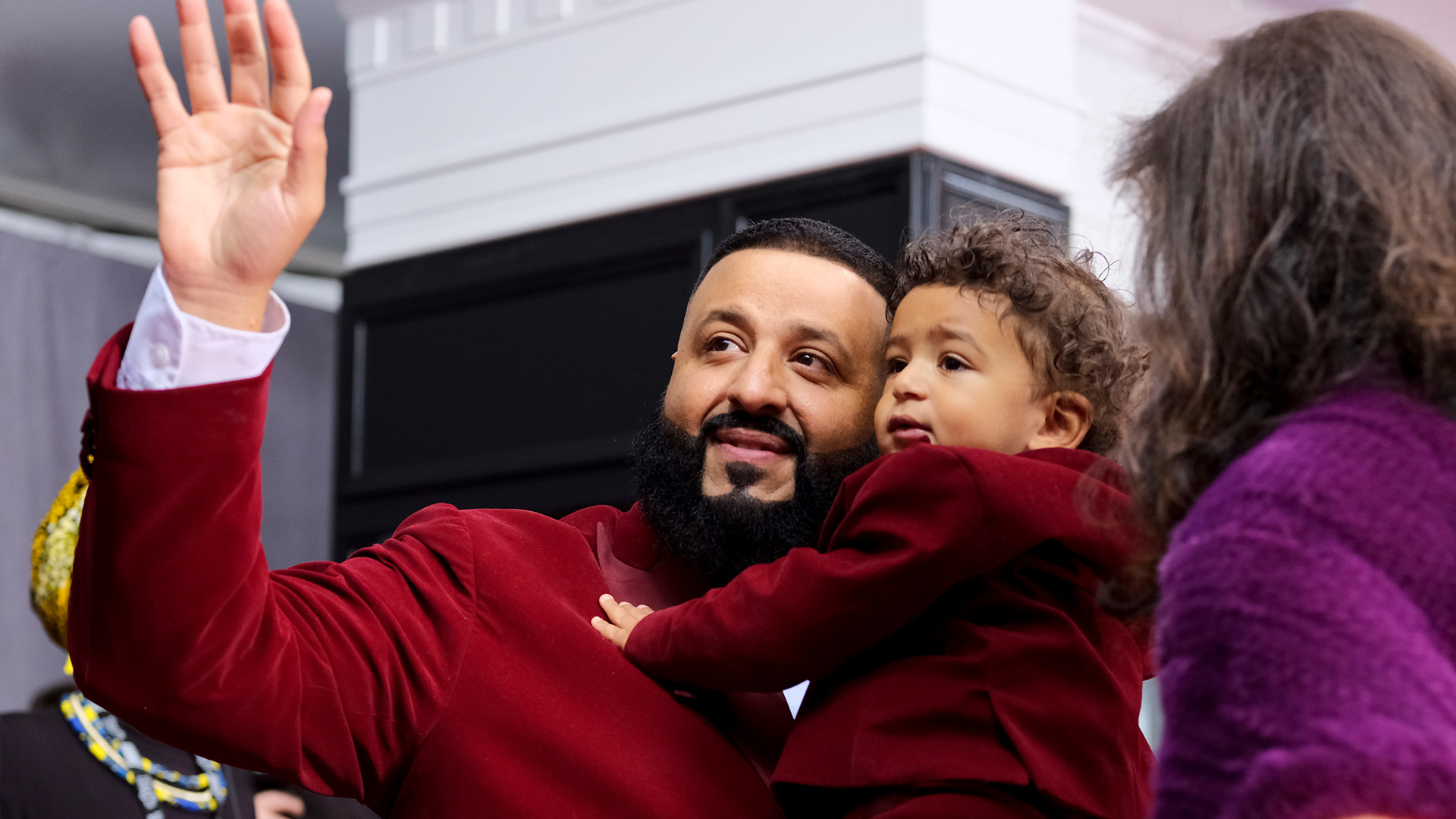 DJ Khaled, who performed at the 60th Annual GRAMMY Awards with Rihanna, waves as he holds his young son, Asahd.
