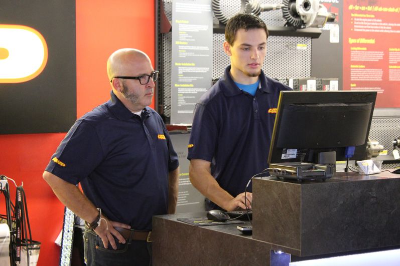 Greg is guided through the parts purchase process by a sales associate. 
