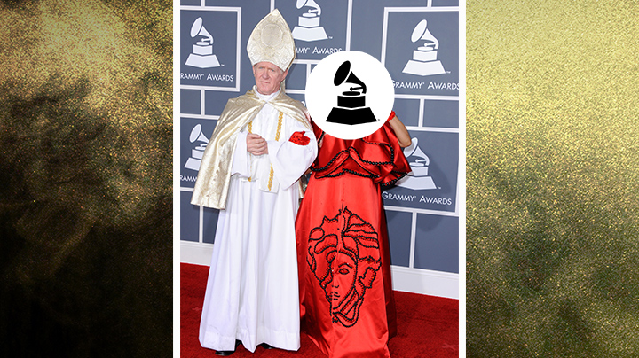 Who wore this red cape and linked arms with a Pope impersonator?