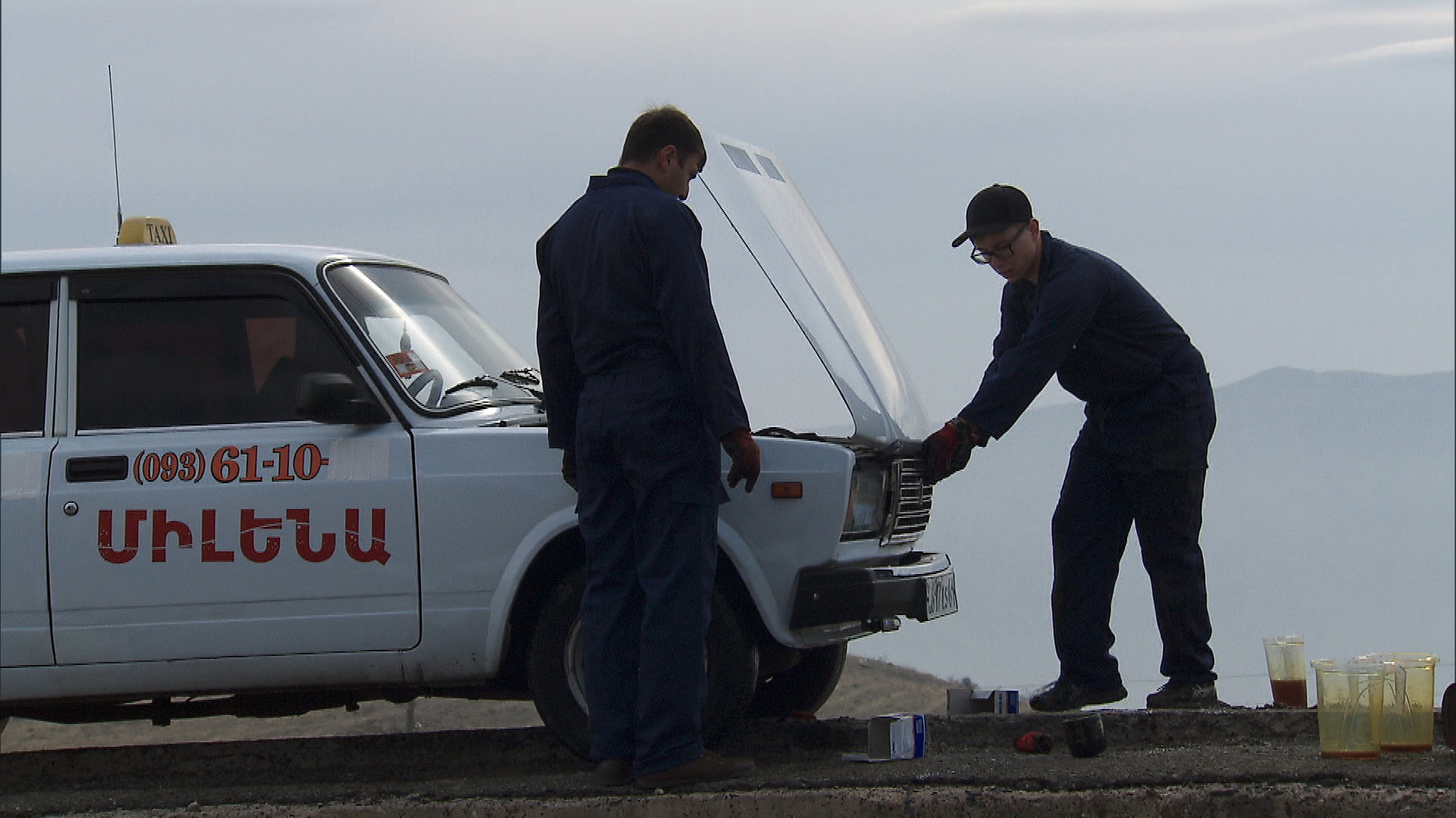 In this Roadblock, Tyler (right) has to change the oil in a Lada taxi.